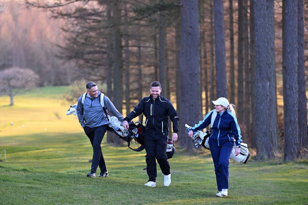 Three golfers enjoying each others company in late evening sunshine at Slaley Hall