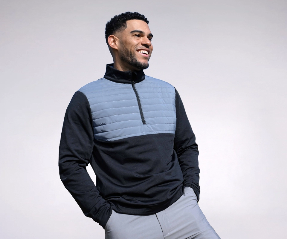 A man in a ProQuip golf midlayer clothing item