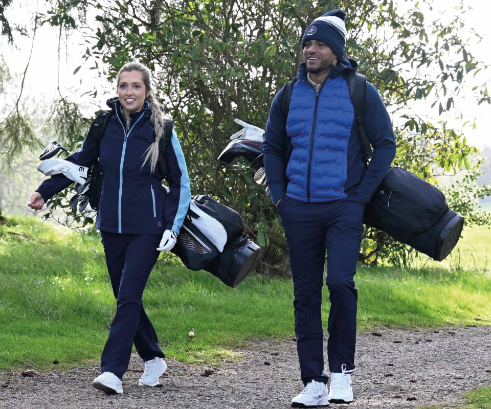 A couple of golfers walking on the golf course